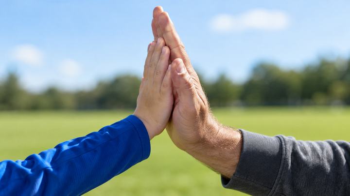 Eine Kinderhand und eine Männerhand beim High Five